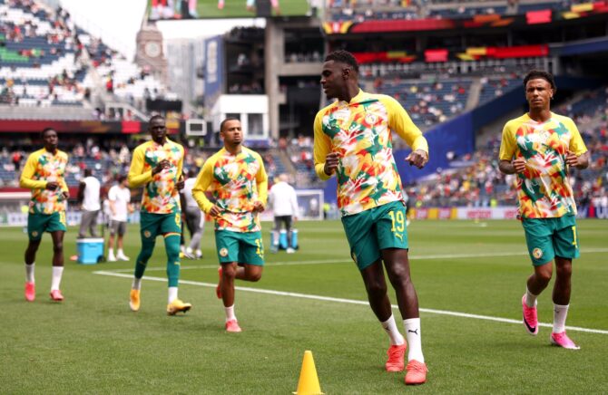 Senegals Nationalspieler wärmen sich vor dem Sechzehntelfinale der WM 2026 gegen Belgien auf, vorn Abwehrspieler Moussa Niakhaté (Nummer 19). Die Szene entstand im Seattle Stadium am 1. Juli 2026 in Seattle. (Fran Santiago / Getty Images)