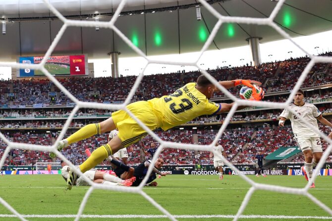 Spaniens Torhüter Unai Simón (Nummer 23) hechtet mit ausgestrecktem Arm nach dem Ball und pariert im Gruppenspiel der Fußball-Weltmeisterschaft 2026 zwischen Uruguay und Spanien am 26. Juni 2026 im Guadalajara Stadium in Zapopan, Mexiko. Die Aufnahme entstand mit einer ferngesteuerten Kamera hinter dem Tor. Carl Recine / Getty Images