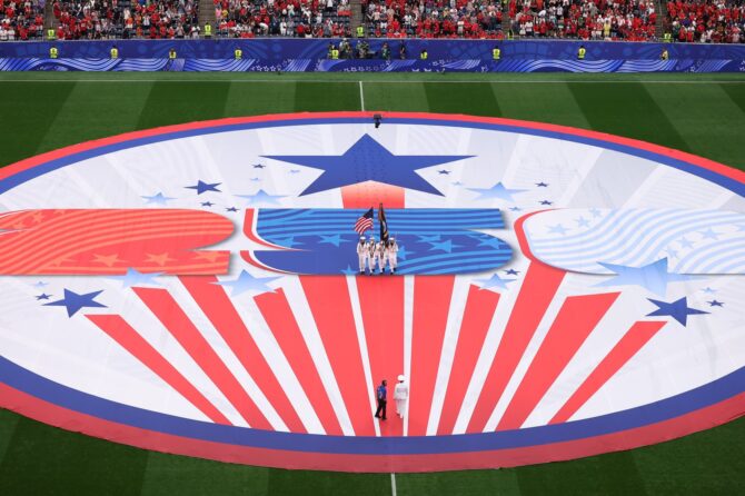 Eine Ehrengarde der US Navy präsentiert die amerikanische Flagge auf einem riesigen Banner zum 250. Geburtstag der USA, das vor dem WM-2026-Achtelfinale zwischen Kanada und Marokko am 4. Juli 2026 den Mittelkreis des Houston Stadium bedeckt. Lars Baron / Getty Images North America via Getty Images