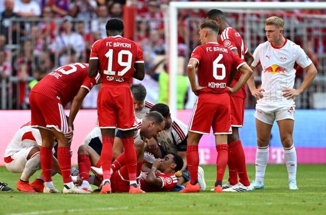 Jamal Musiala wird auf dem Rasen der Allianz Arena medizinisch behandelt. Der Torschütze zum 3:1 musste im Telekom Cup des FC Bayern München gegen RB Leipzig am 15. August 2026 kurz vor Schluss versorgt und ausgewechselt werden. (Christian Kaspar-Bartke / Getty Images Europe via Getty Images)