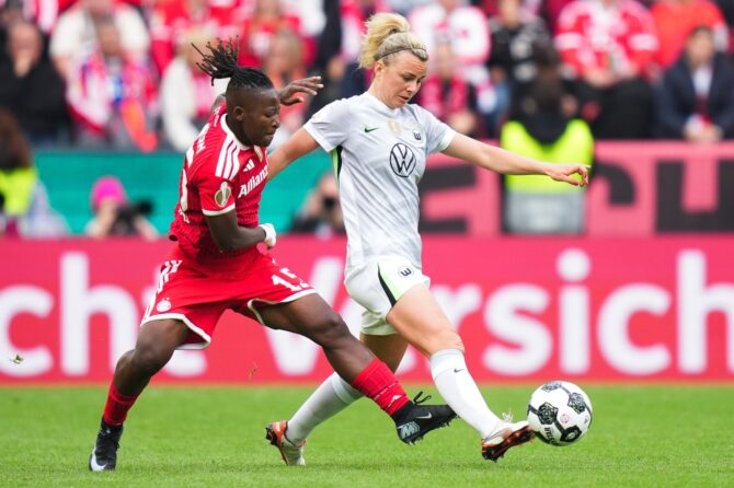 Lena Lattwein vom VfL Wolfsburg wird von Bernadette Amani vom FC Bayern München unter Druck gesetzt. Die beiden Mittelfeldspielerinnen lieferten sich im DFB-Pokalfinale der Frauen am 14. Mai 2026 im Kölner RheinEnergieStadion hitzige Duelle. (Pau Barrena / Getty Images)