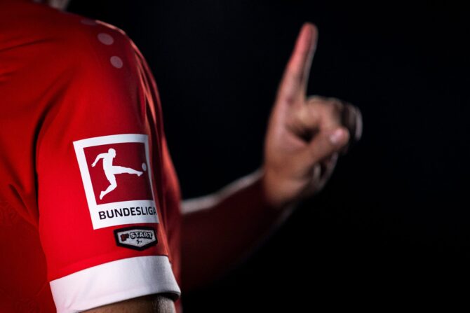 Fabio Gruber trägt das Startelfdebüt-Patch am Ärmel des roten Trikots von Mainz 05