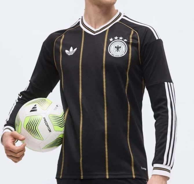 Das schwarz-goldene adidas-Abschiedstrikot des DFB 2026 mit goldenen Zickzack-Nadelstreifen, weiss-gold gefasstem V-Ausschnitt, adidas-Trefoil und historischem DFB-Wappen mit vier Sternen. (Bild: Footy Headlines)
