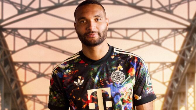 Jonathan Tah vom FC Bayern München im neuen adidas Wiesn Trikot 2026 mit goldenem Telekom-Logo und Sonderwappen. (Foto: adidas)